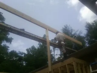 Carpenter setting a ridge beam over a new addition frame — Ice Dam Removal by Roofing Brothers in Donora