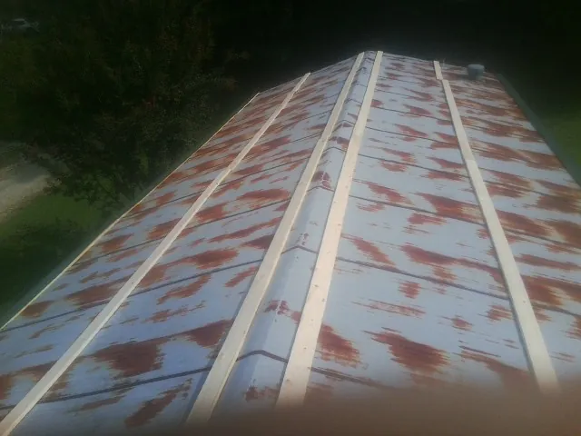 Rusted metal roof panels with new wood purlins before replacement — Storm Damage Roof Repair in Donora by Roofing Brothers