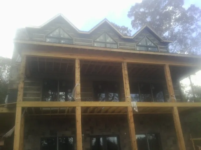 Dormers and porch framing on a large log home under construction — Roof Coating work by our crew in Donora