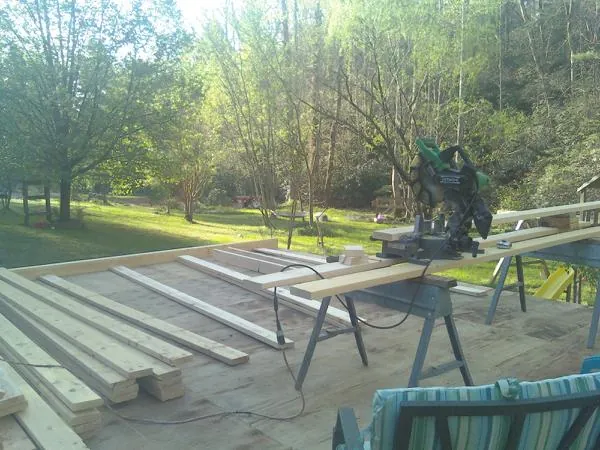 Miter saw and framing lumber on a deck under construction in Donora
