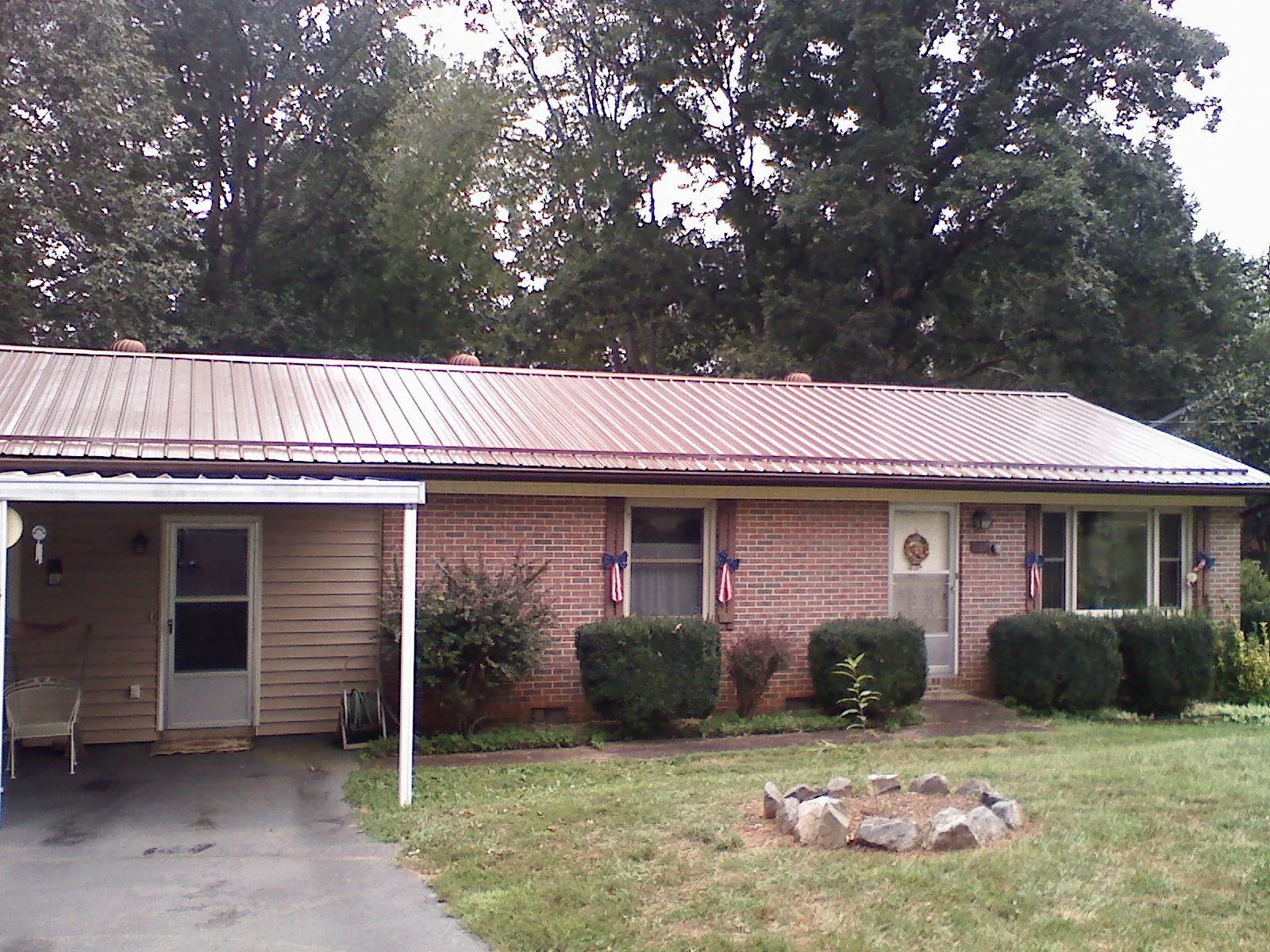 Bronze metal roof and carport on a brick ranch home — Roof Repair work by our crew in Donora